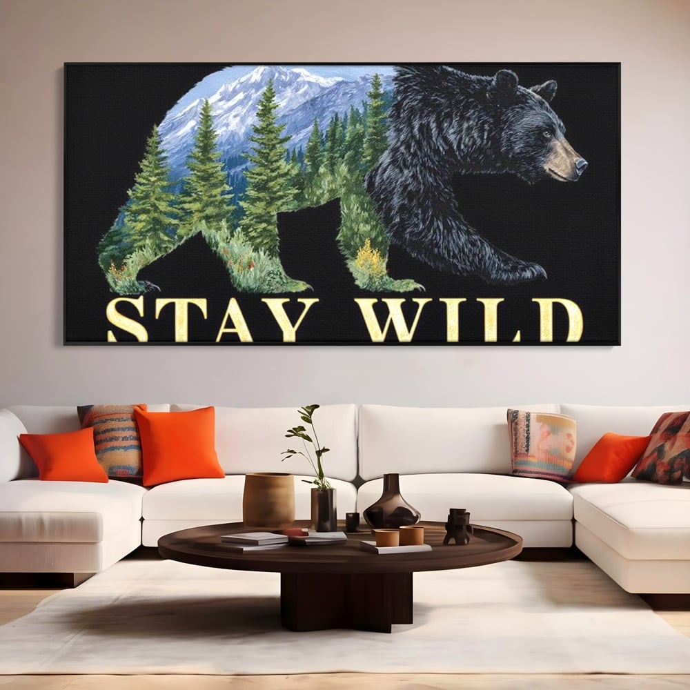 Tablou canvas cu tablou canvas cu silueta de urs si munti, in rama de aluminiu negru, pe perete intr-un living